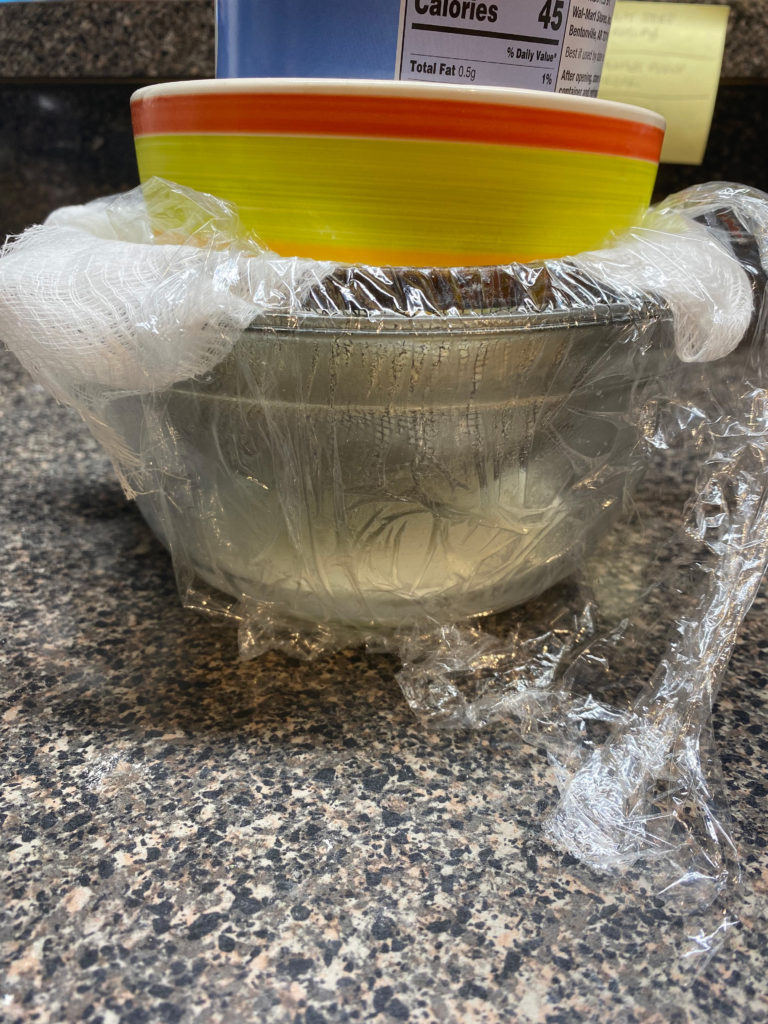 Air fryer cannoli prep: drained ricotta, in draining contraption.