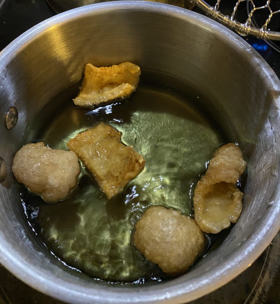 Pork rinds frying in canola oil